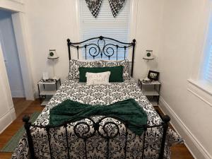 a bedroom with a black and white bed with green sheets at Sandstone Street Bed and Breakfast in Llano