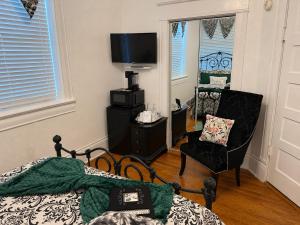 a bedroom with a bed and a chair and a television at Sandstone Street Bed and Breakfast in Llano