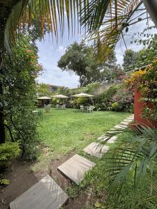 a garden with picnic tables and umbrellas on the grass at Alana Hotel By ISH in Antigua Guatemala