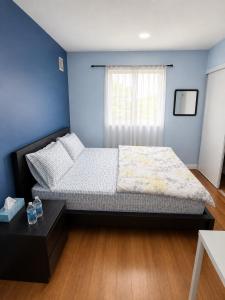a bedroom with a bed and a blue wall at one bedroom in Brampton in Brampton