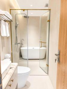 a bathroom with a glass shower and a bath tub at Annava Hotel & Coffee in Hai Phong