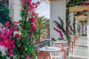 a row of tables and chairs with pink flowers at Meliá Alicante in Alicante