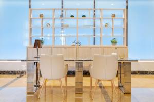 a kitchen with two white chairs and a table at Meliá Alicante in Alicante