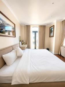 a large white bed in a hotel room at Annava Hotel & Coffee in Hai Phong