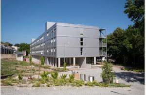 a large building in a parking lot with trees at K204 junto à Universidade in Guimarães