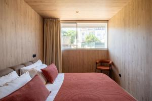 a bedroom with a bed with a red blanket and a window at K204 junto à Universidade in Guimarães