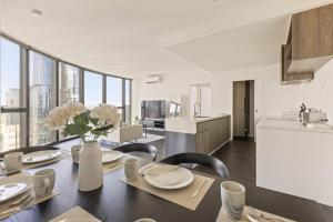 a kitchen and dining room with a table and chairs at Park Avenue - UNO Melbourne in Melbourne