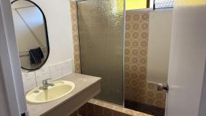 a bathroom with a sink and a glass shower at Room 1 Bright Spacious Room Walk to Shops in Kelmscott