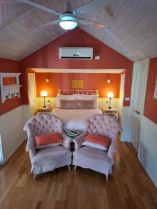 a bedroom with a large bed and two chairs at Bella Rouge Cottage in Bright +15 photos