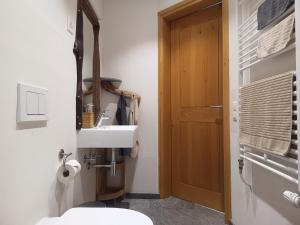 a bathroom with a sink and a wooden door at Guesthouse "Castello del Nucleo" in Intragna +55 photos