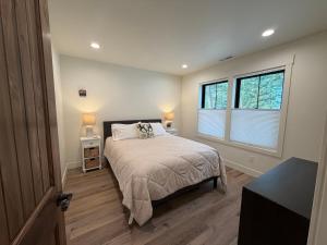 a bedroom with a bed and two windows at Hungry Horse Farmhouse in Hungry Horse