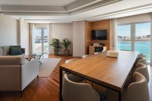 a living room with a large table and chairs at Meliá Maria Pita in A Coruña