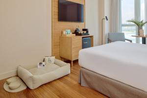 a hotel room with a bed and a chair at Meliá Maria Pita in A Coruña