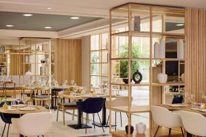 a restaurant with tables and chairs and windows at Meliá Maria Pita in A Coruña