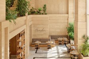 a restaurant with tables and chairs and plants at Meliá Maria Pita in A Coruña +46 photos