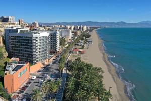 a view of a beach with palm trees and buildings at Meliá Costa del Sol in Torremolinos