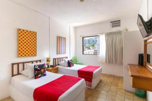 a hotel room with two beds and a tv at Emperador Vallarta Beachfront Hotel and Suites in Puerto Vallarta