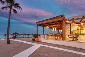 a restaurant on the beach with a palm tree at Meliá Costa del Sol in Torremolinos +116 photos