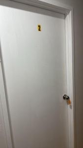 a white door with a danger sign on it at Room 2 Bright Spacious Room Walk to Shops in Kelmscott