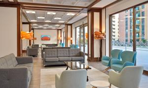 a waiting room with couches and chairs and windows at SOL by Meliá Torremolinos Don Pablo in Torremolinos