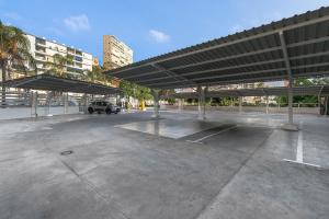 a large parking lot with a car parked under awning at SOL by Meliá Torremolinos Don Pablo in Torremolinos