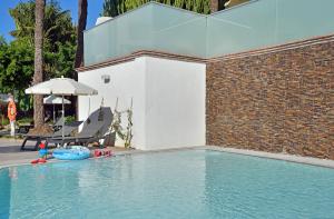 a swimming pool with a chair and an umbrella at SOL by Meliá Torremolinos - Don Pedro in Torremolinos
