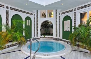 a hot tub in a room with green and white walls at SOL by Meliá Torremolinos - Don Pedro in Torremolinos