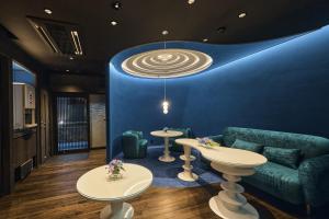 a room with a couch and tables and a blue wall at Wakasa Annex in Nara