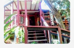 a red house with a staircase and a tree at WELCOME TO My COTTAGE in Sunland
