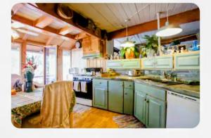 a kitchen with green cabinets and a stove top oven at WELCOME TO My COTTAGE in Sunland