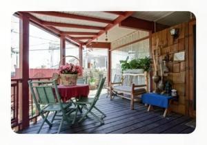 a screened in porch with a table and chairs at WELCOME TO My COTTAGE in Sunland +7 photos