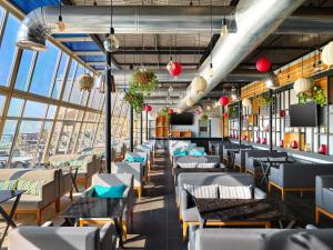 a restaurant with tables and chairs and a large window at ibis Kuwait Salmiya in Kuwait