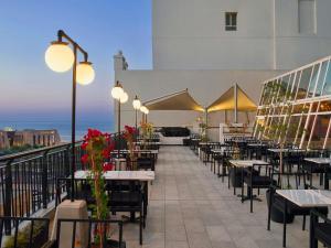a restaurant with tables and chairs on a balcony at ibis Kuwait Salmiya in Kuwait