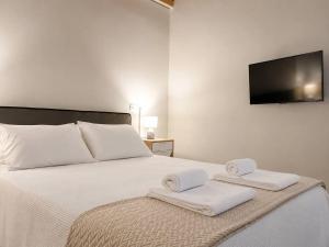 a bedroom with a bed with two towels on it at Blue Topaz cottage Mini pool Spa in Nafplio +14 photos