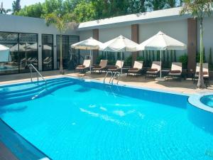 a large blue swimming pool with chairs and umbrellas at Novotel Cairo El Borg in Cairo