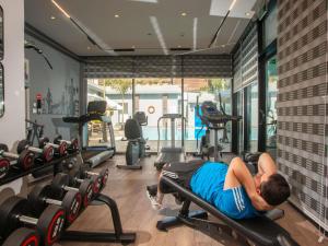 a man laying on a bench in a gym at Novotel Cairo El Borg in Cairo