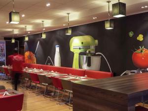 a restaurant with a table and a green robot on the wall at Ibis Lagos Ikeja in Ikeja