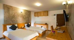 a hotel room with two beds and a desk at At home boutique in Ban Long