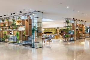 a lobby of a building with plants on shelves at Meliá Sevilla in Seville