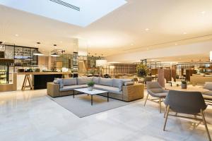 a living room with a couch and tables and chairs at Meliá Sevilla in Seville +126 photos