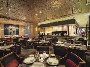 a restaurant with tables and chairs and a bar at Grand Lisboa Macau in Macau