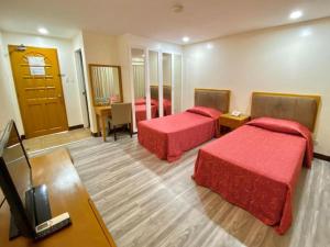 a hotel room with two beds and a television at Bayfront Hotel Subic in Olongapo