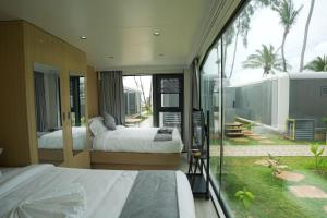 a bedroom with two beds and a balcony with palm trees at Sea Side Resort in Paje