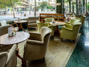 a restaurant with tables and chairs and a street at Meliá Plaza Valencia in Valencia