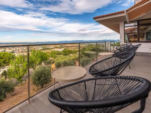 a deck with chairs and tables on a balcony at Meliá Castelo Branco in Castelo Branco