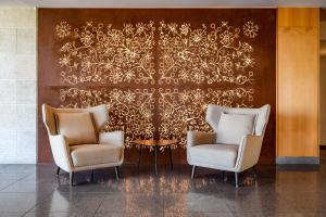 two chairs and a table in front of a wall at Meliá Castelo Branco in Castelo Branco +45 photos