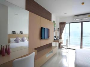 a bedroom with a bed and a tv on a wall at Landmark Residence in Ban Khlong Sanam Phli