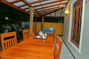 a wooden table with chairs in a room at veranda guest home in Mirissa