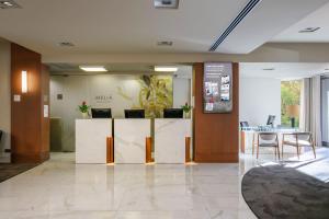 an office lobby with a reception desk and a table at Meliá Setúbal in Setúbal