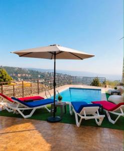 a villa with a swimming pool and an umbrella at Rickystone in Jiwār al Bawāshiq